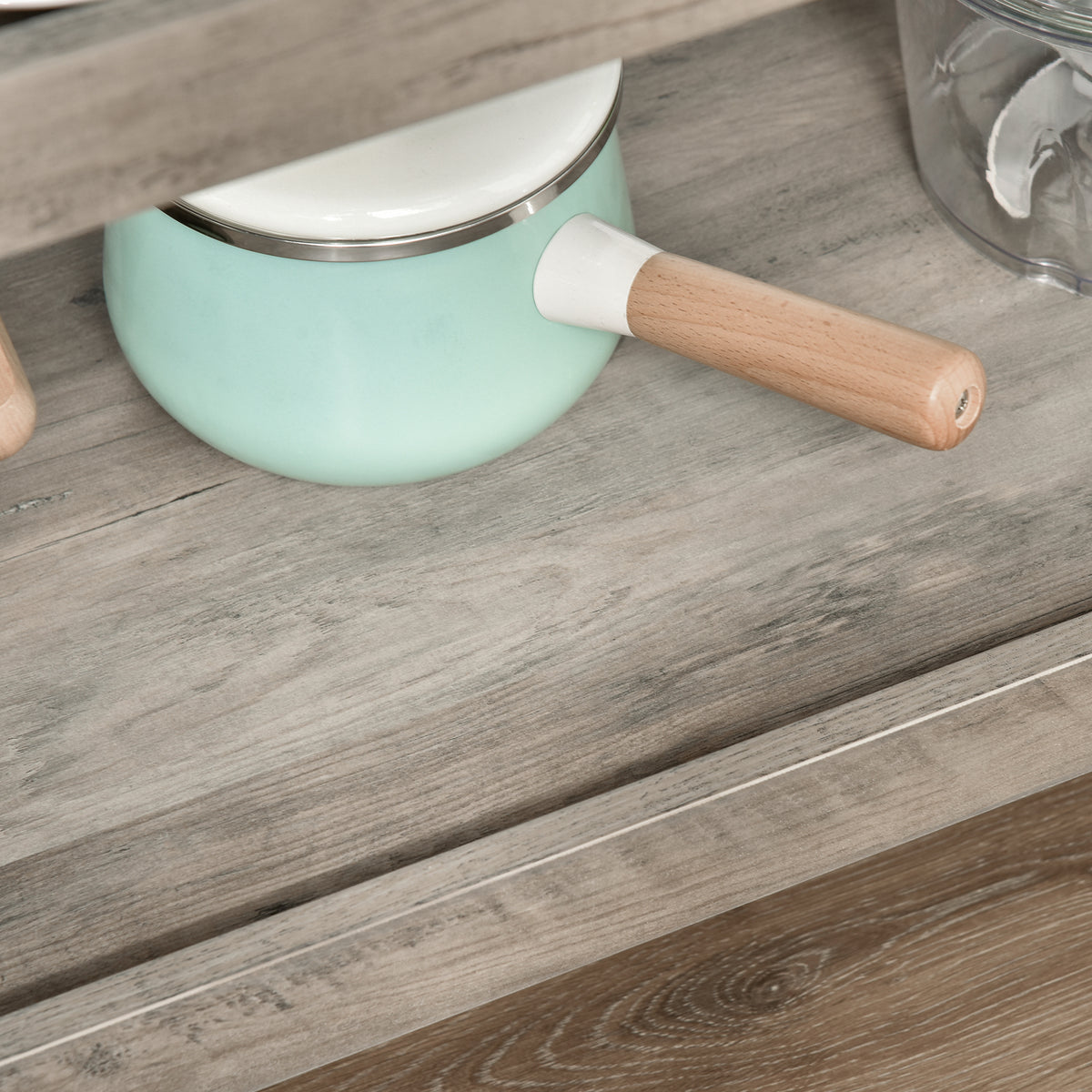 Light blue pot with a wooden handle on a wooden surface