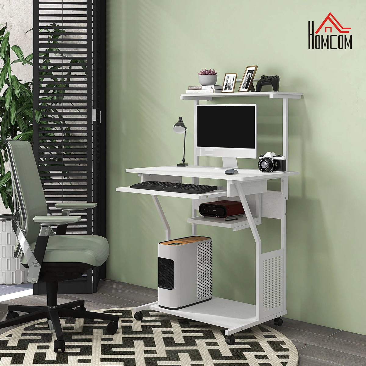 White computer desk with a chair and monitor in a room with green walls and a patterned rug.