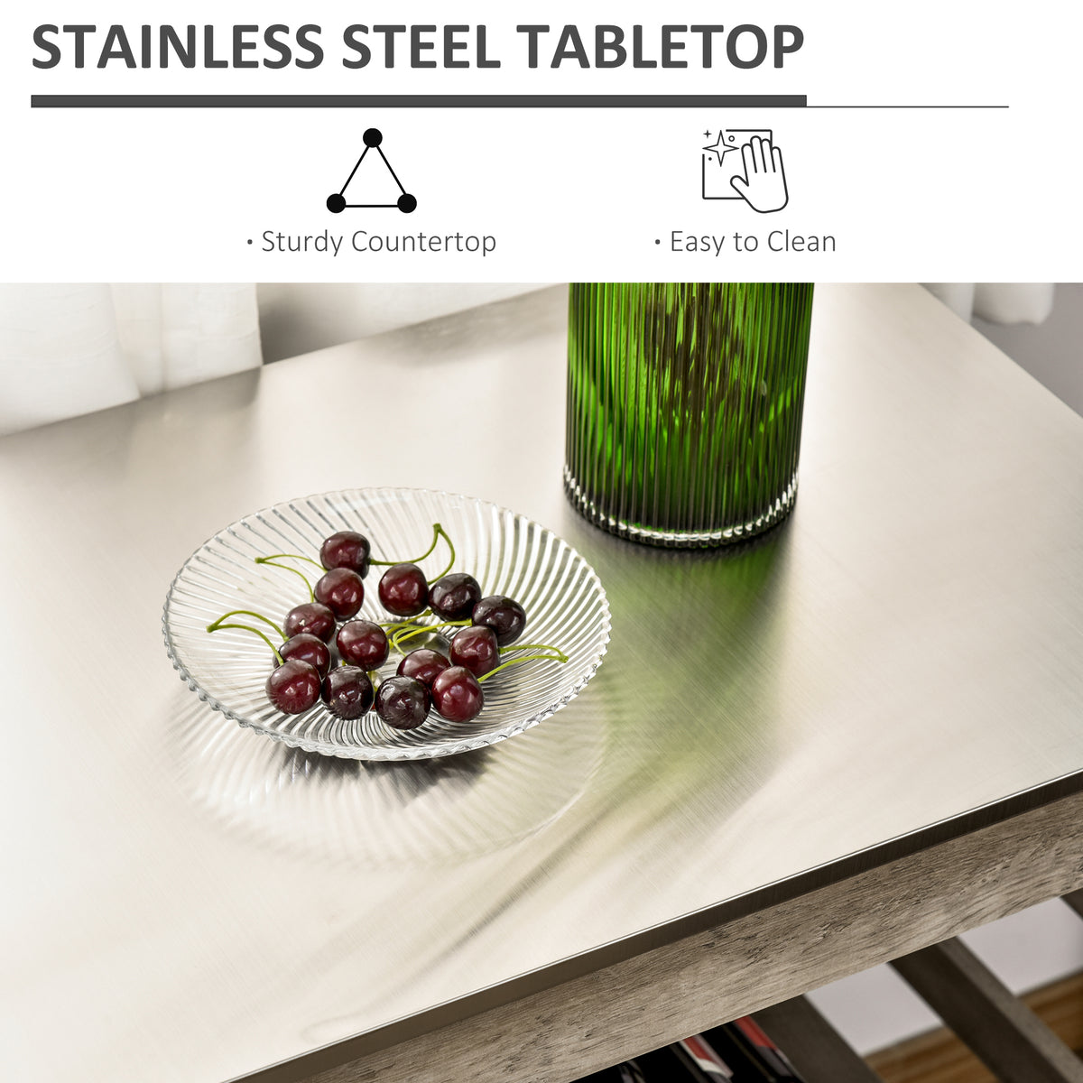 Stainless steel tabletop with a glass of green juice and a bowl of cherries.