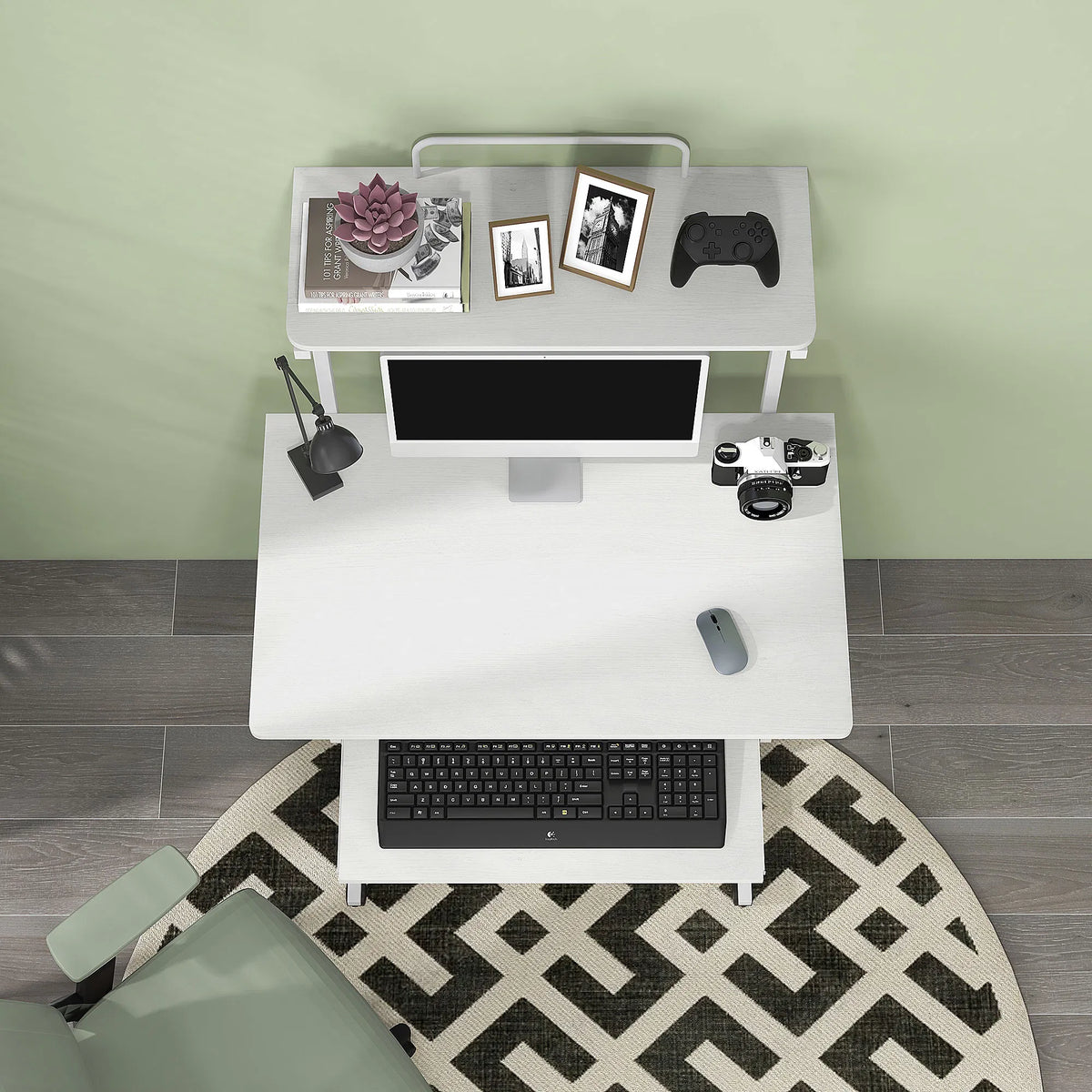 A white two-tier standing desk with a pull-out keyboard tray, styled with a computer monitor, keyboard, mouse, books, and decorative items, set against a sage green wall and gray wood floor.