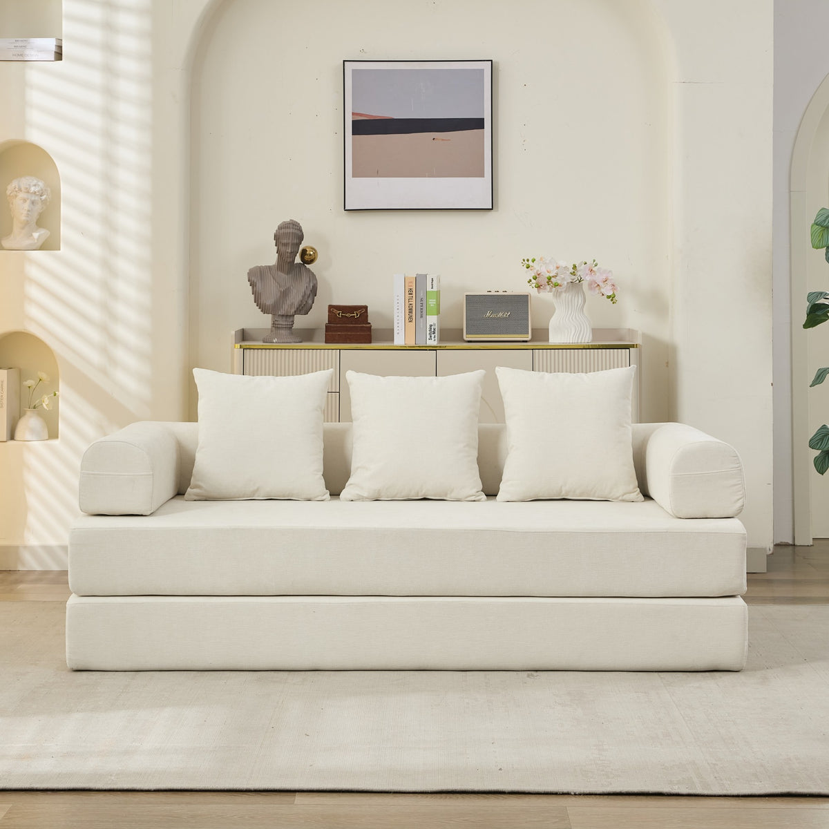 White sofa with white cushions in a minimalistic living room.