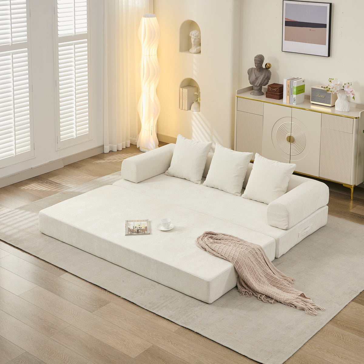 White sofa bed in a modern living room with decor elements.